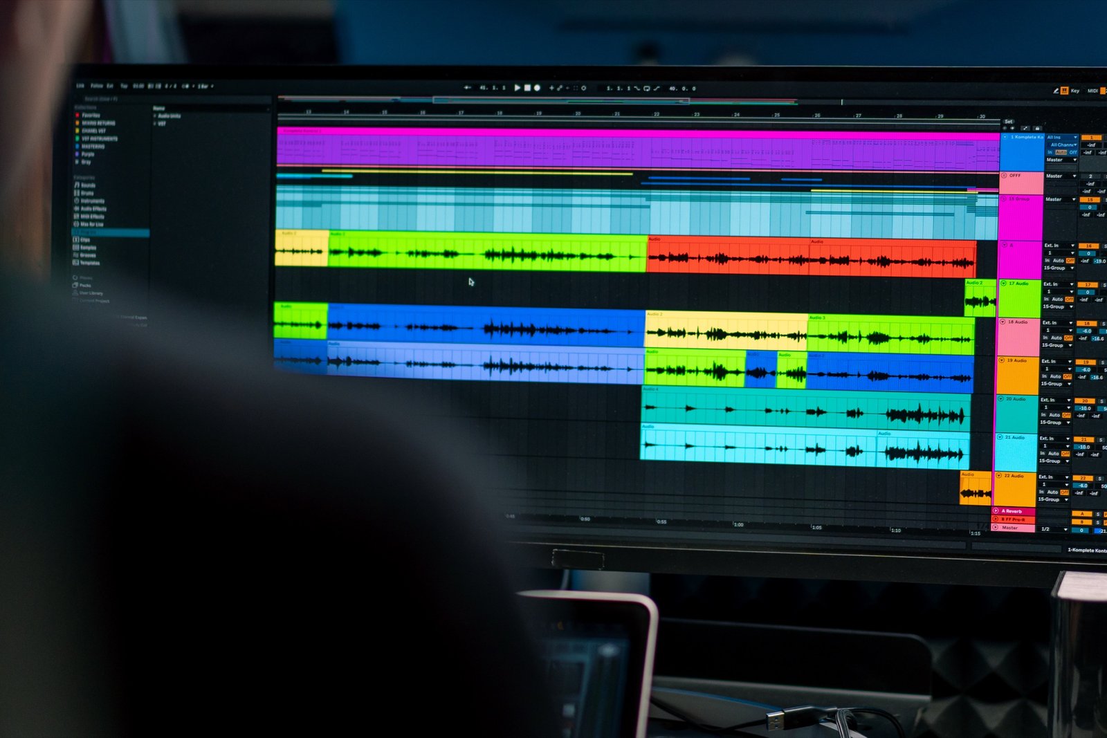 A sound engineer's screen showing colorful audio waveform tracks during a mix session.